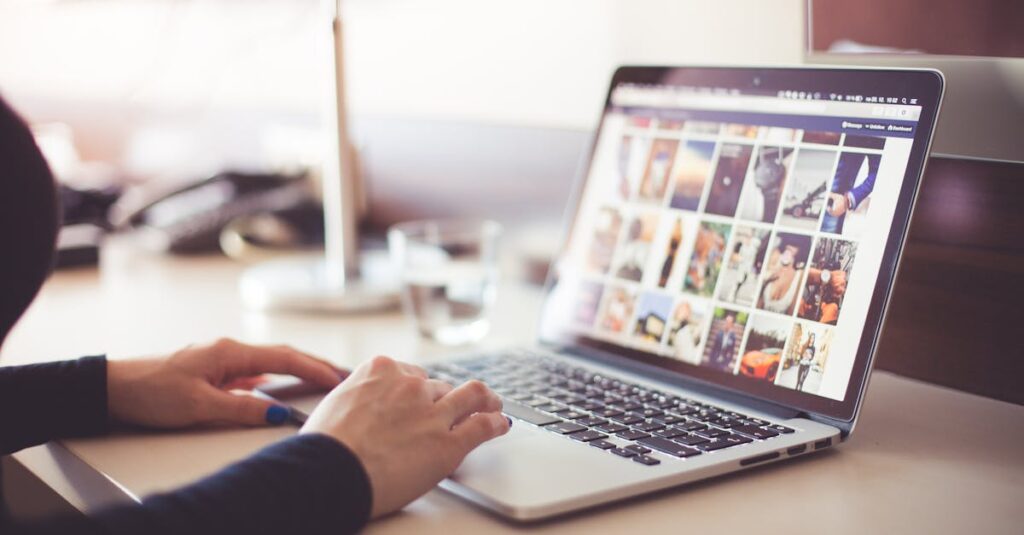 Close-up of hands typing on a laptop with an image gallery open on the screen to organize family memories online.