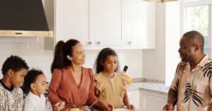 A cheerful family gathered in the kitchen, preparing a meal and enjoying each other's company.