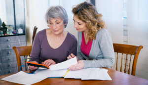 mother and adult daughter working at kitchen table